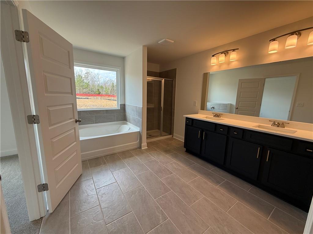 3979 Streamlet Way, Unit 153 Gainesville, GA 30506 - Photo 17 of 17 a spacious bathroom with a vanity a sink a mirror and a bathtub