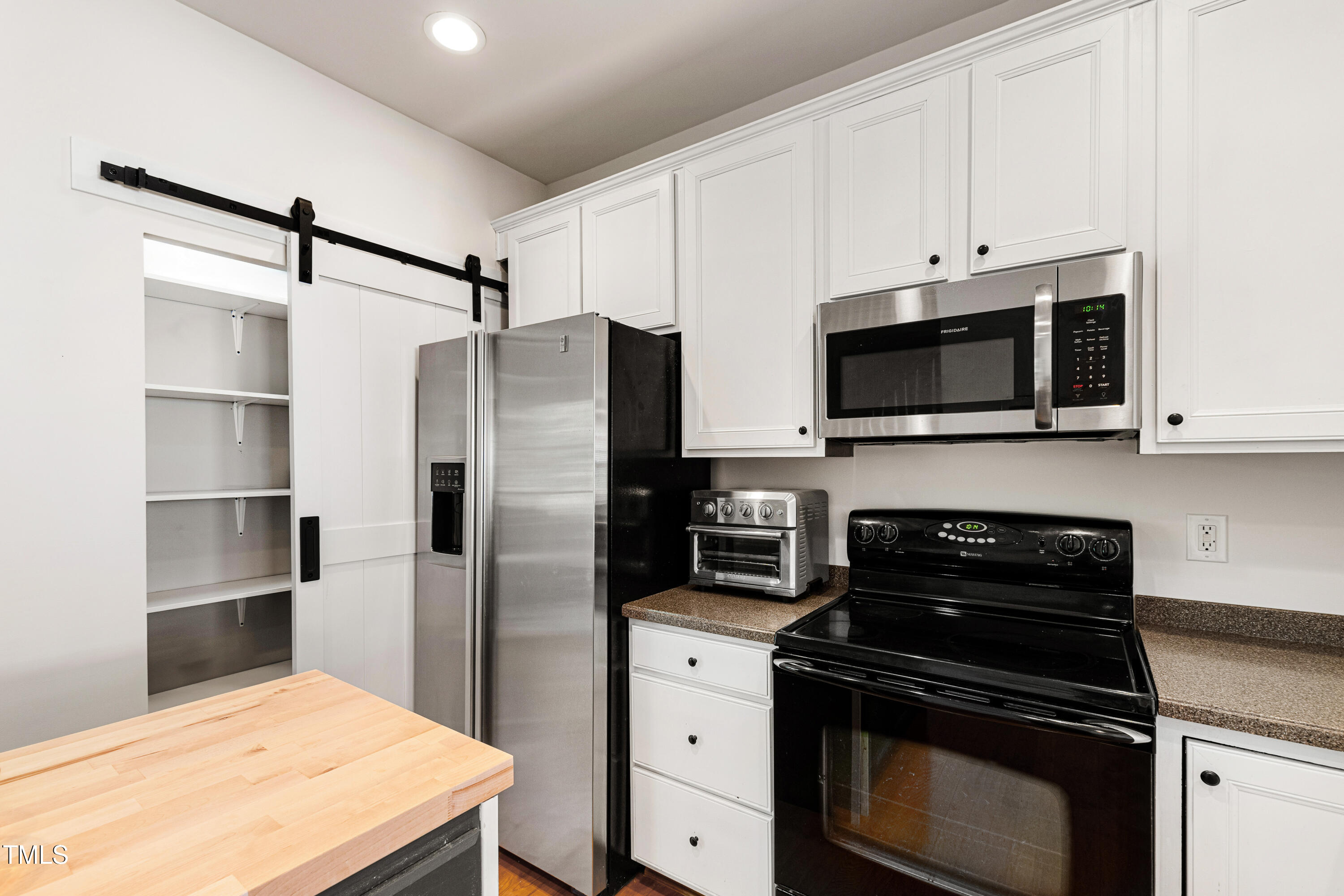 7761 Winners Edge Street Raleigh, NC 27617 - Photo 12 of 44 a kitchen with white cabinets and stainless steel appliances