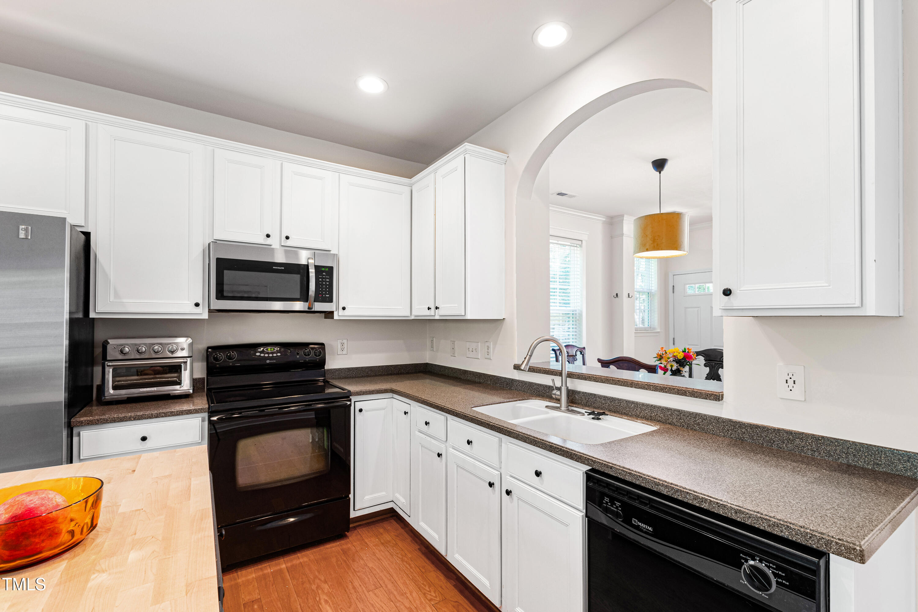 7761 Winners Edge Street Raleigh, NC 27617 - Photo 13 of 44 a kitchen with stainless steel appliances a stove a sink cabinets and a window