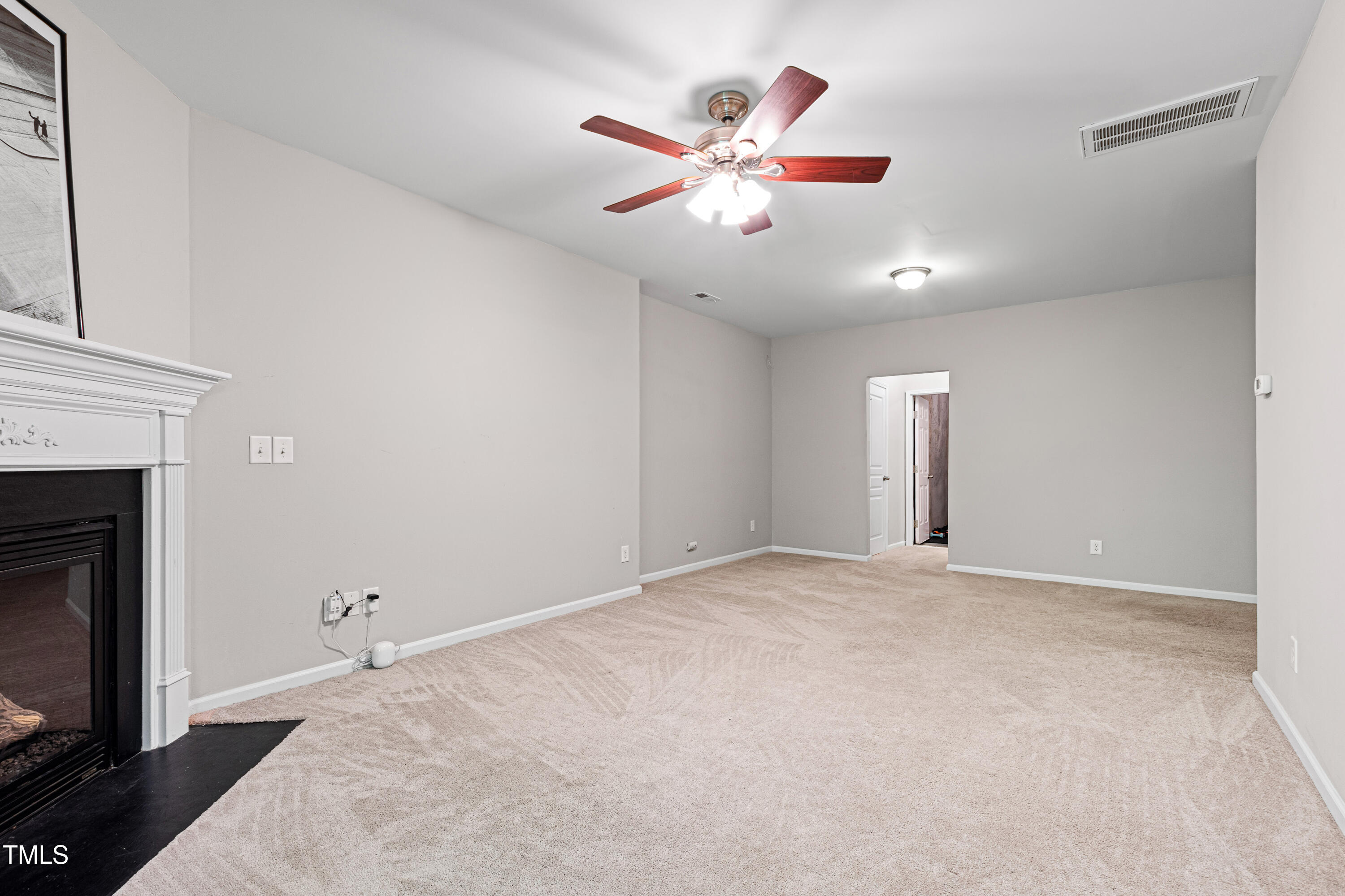 7761 Winners Edge Street Raleigh, NC 27617 - Photo 30 of 44 an empty room with chandelier fan and fireplace