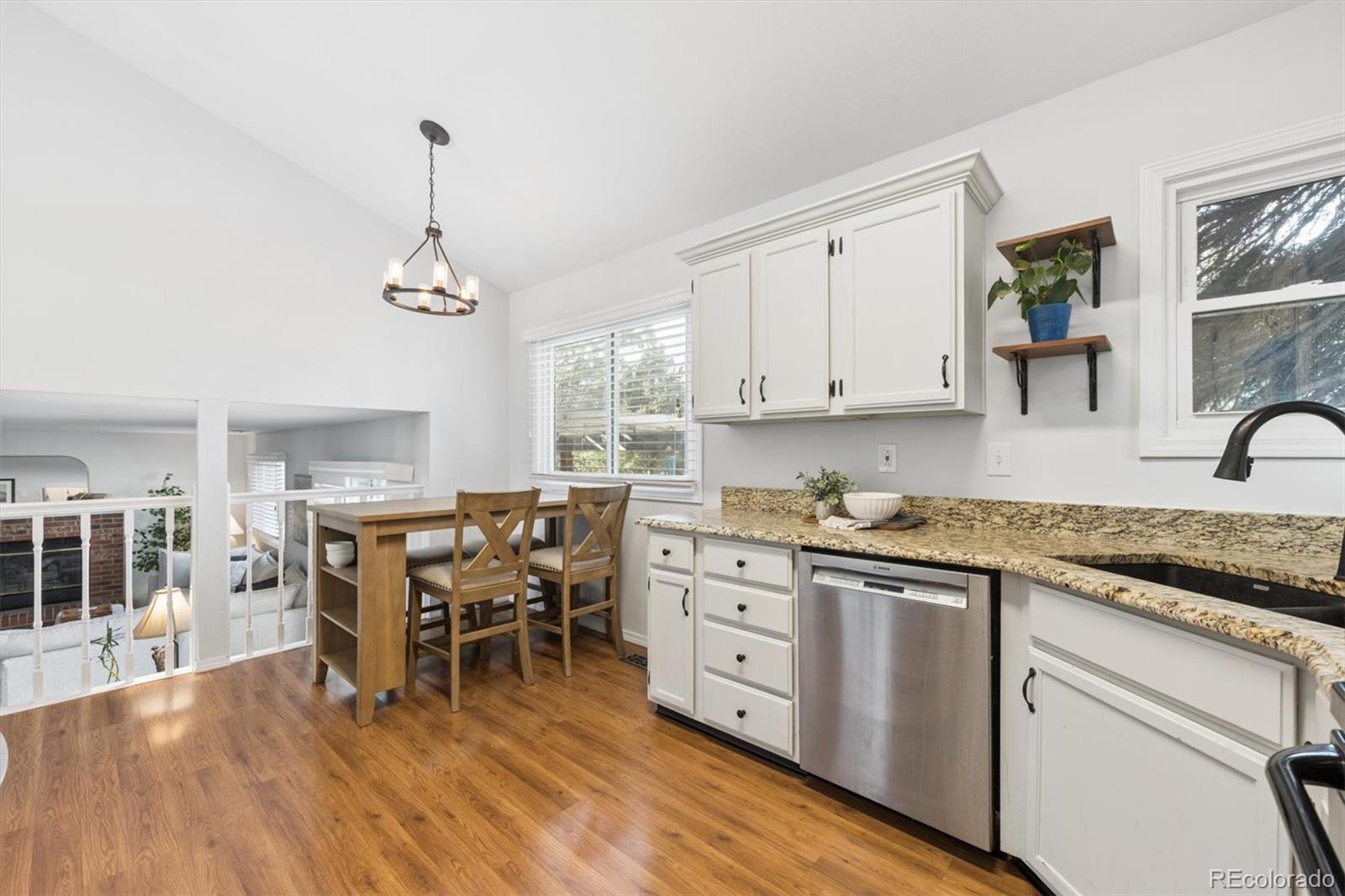 7191 Palisade Drive Highlands Ranch, CO 80130 - Photo 12 of 39 a kitchen with stainless steel appliances granite countertop a stove a sink dishwasher a microwave oven with white cabinets and wooden floor