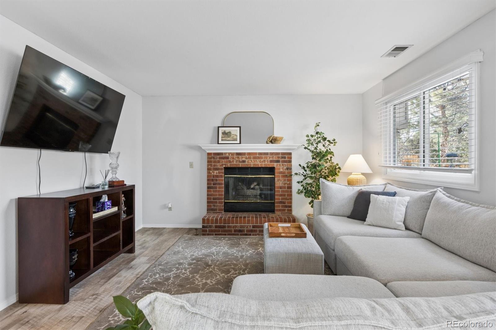 7191 Palisade Drive Highlands Ranch, CO 80130 - Photo 19 of 39 a living room with furniture a flat screen tv and a fireplace