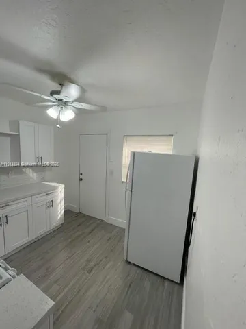 a view of a kitchen with a sink dishwasher and wooden floor