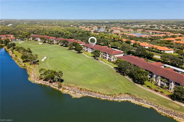 an aerial view of a city with lots of residential buildings ocean and mountain view in back