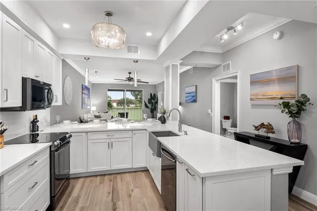 a kitchen that has a lot of cabinets in it and wooden floors