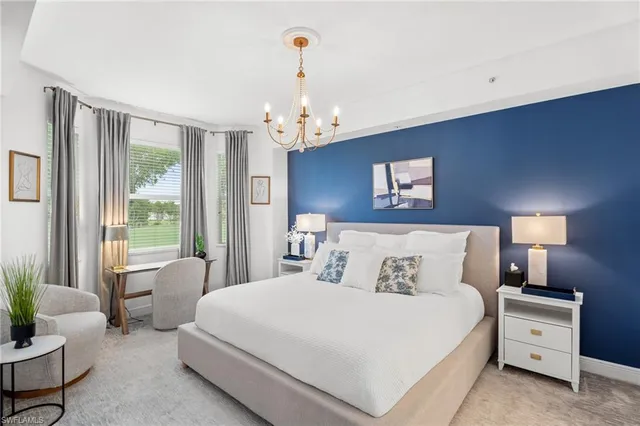 a bedroom with a large bed and a chandelier