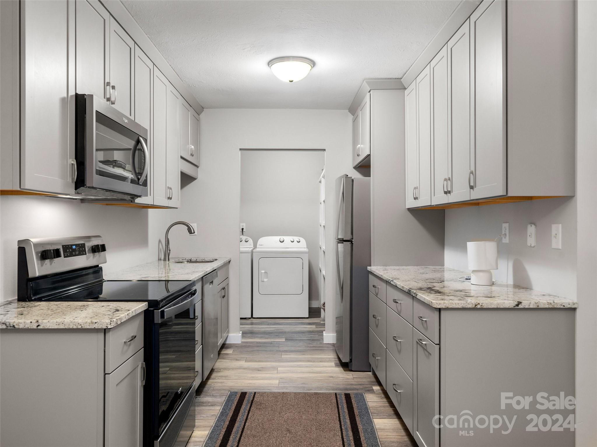 111 Shepard Square, Unit 608 Brevard, NC 28712 - Photo 6 of 29 a kitchen with stainless steel appliances granite countertop a sink stove and refrigerator