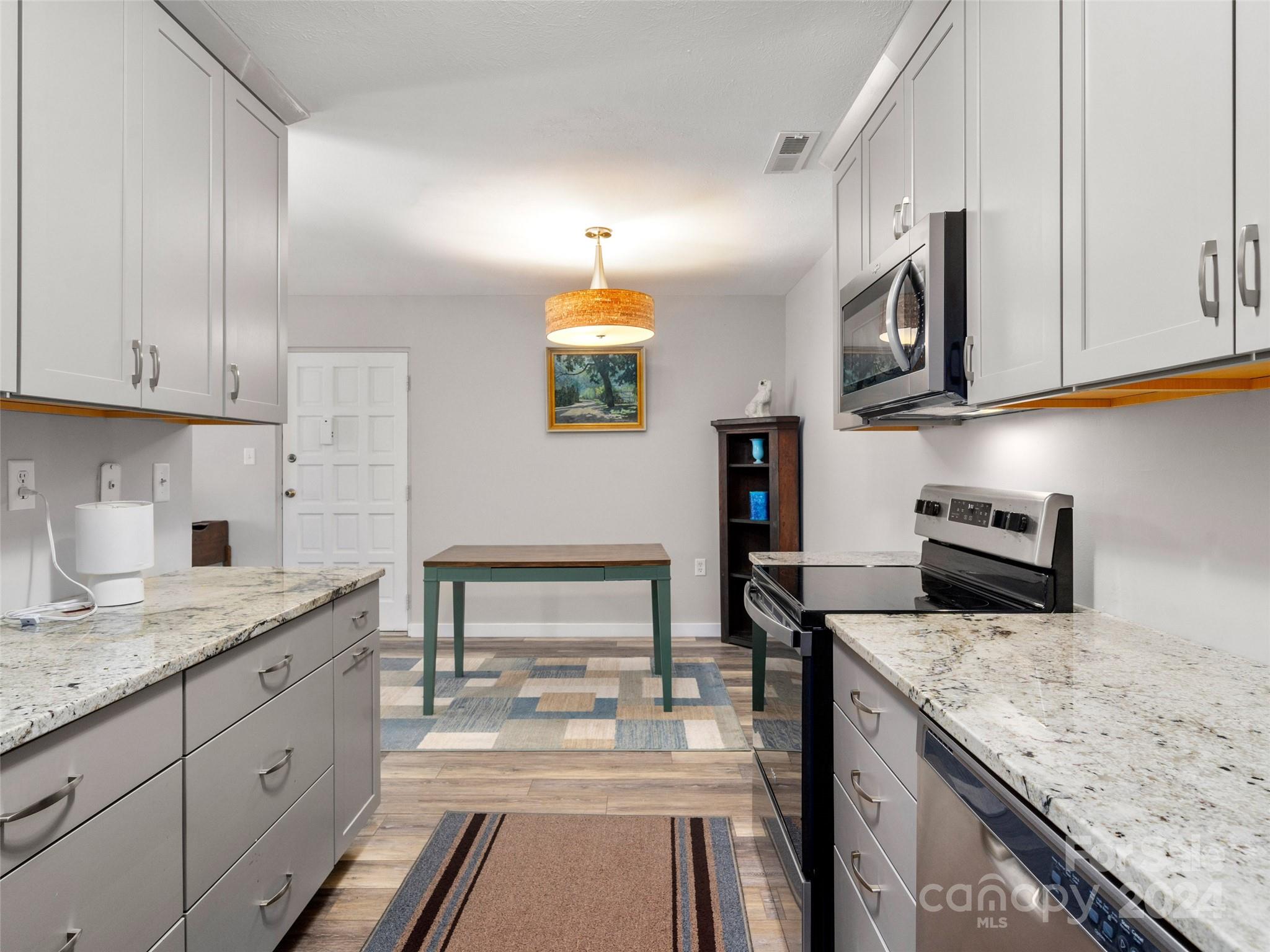 111 Shepard Square, Unit 608 Brevard, NC 28712 - Photo 10 of 29 a kitchen with granite countertop a sink stainless steel appliances and cabinets