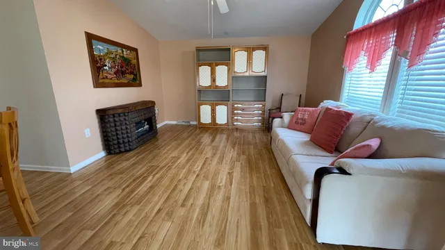 a living room with furniture and a wooden floor