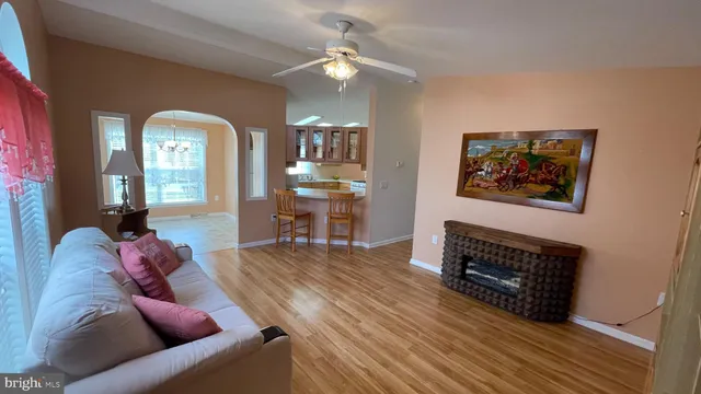 a living room with furniture a fireplace and a chandelier