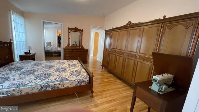 a bedroom with a bed and a mirror on dresser
