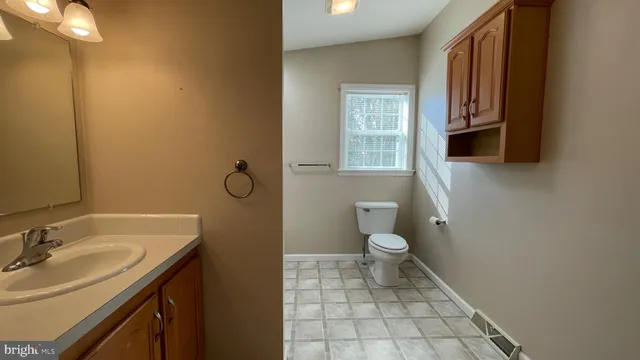 a spacious bathroom with a toilet sink and mirror