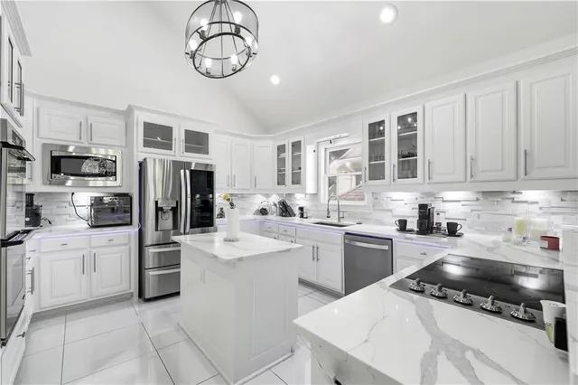 a kitchen with stainless steel appliances kitchen island granite countertop a sink and cabinets