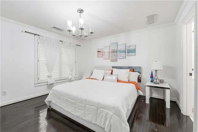 a spacious bedroom with a bed and wooden floor