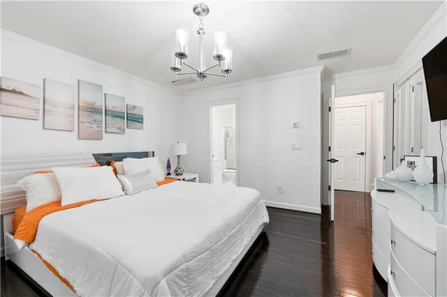 a bedroom with two beds and a large mirror with wooden floor