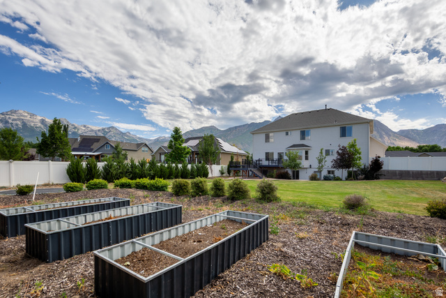 868 Braddock Lane Alpine, UT 84004 - Photo 60 of 64 Expansive backyard featuring multiple raised garden beds, a spacious lawn area, and a white privacy fence