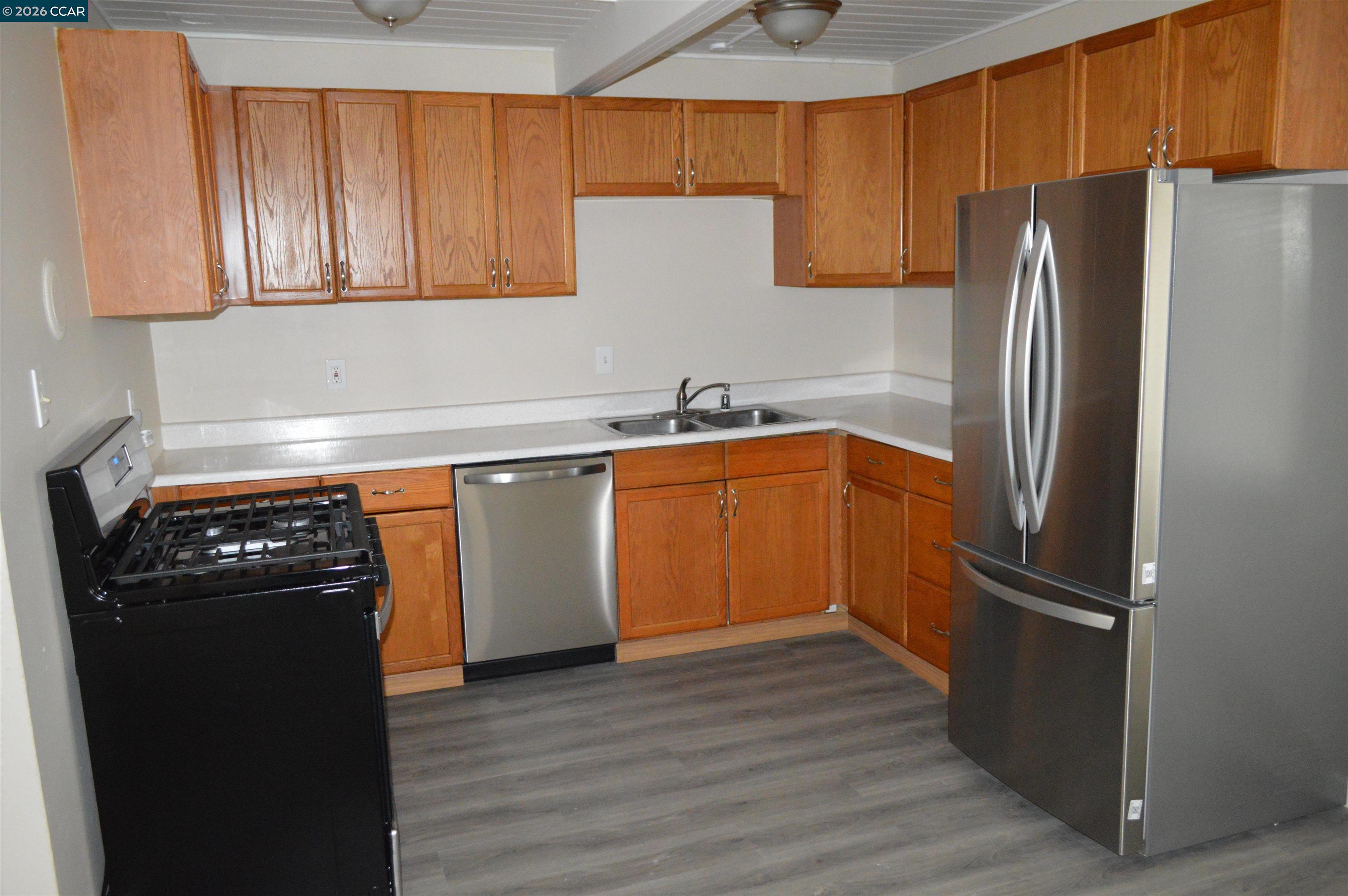 93 Beach Drive Bay Point, CA 94565 - Photo 2 of 9 a kitchen with stainless steel appliances granite countertop a refrigerator a sink and wooden cabinets