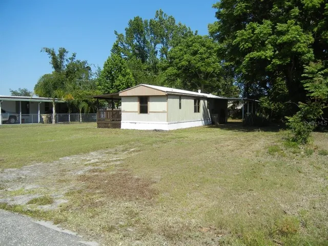 a front view of a house with a yard and trees