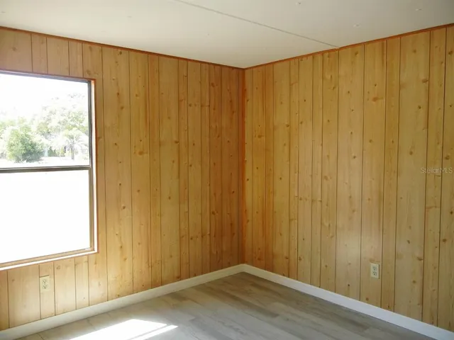 a view of a small space with wooden floor and a window