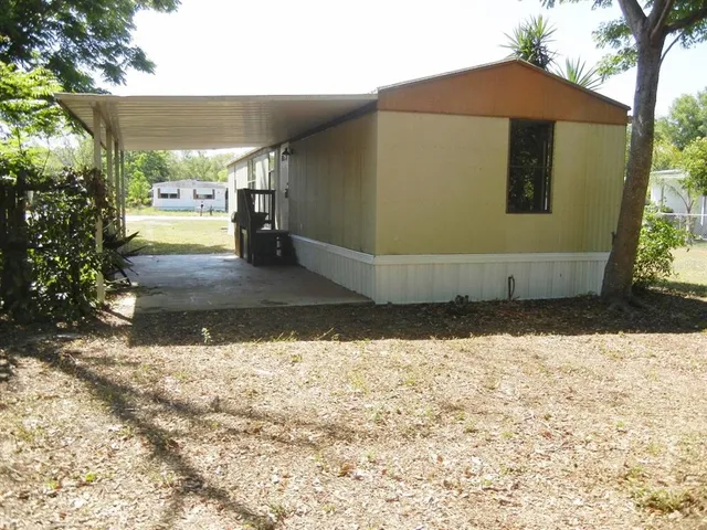 a view of a small house with wooden fence