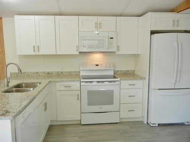 a kitchen with white cabinets and white appliances