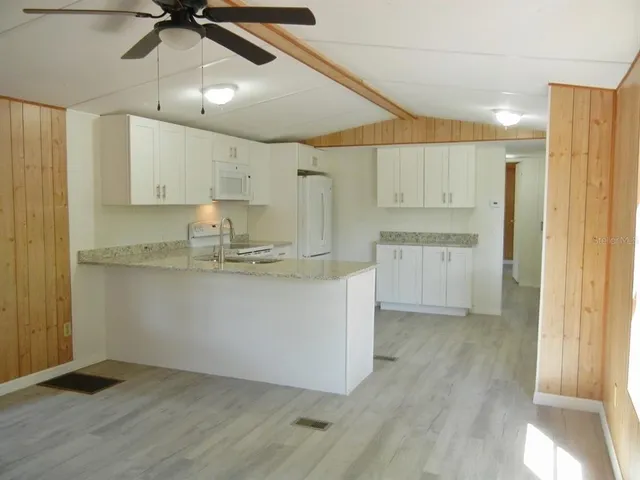 a kitchen with kitchen island a sink a stove and cabinets
