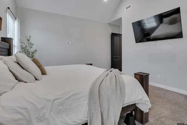 a bedroom with a bed and flat screen tv