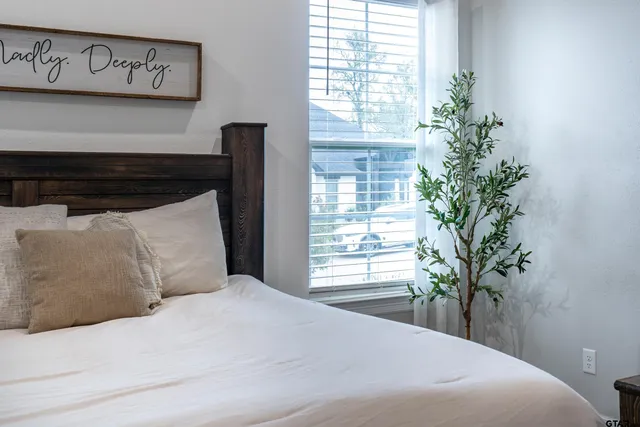 a bedroom with a large bed and a potted plant