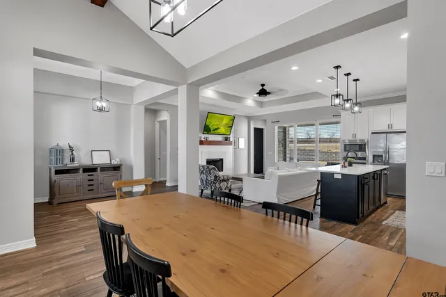 a room with stainless steel appliances kitchen island granite countertop furniture and wooden floor