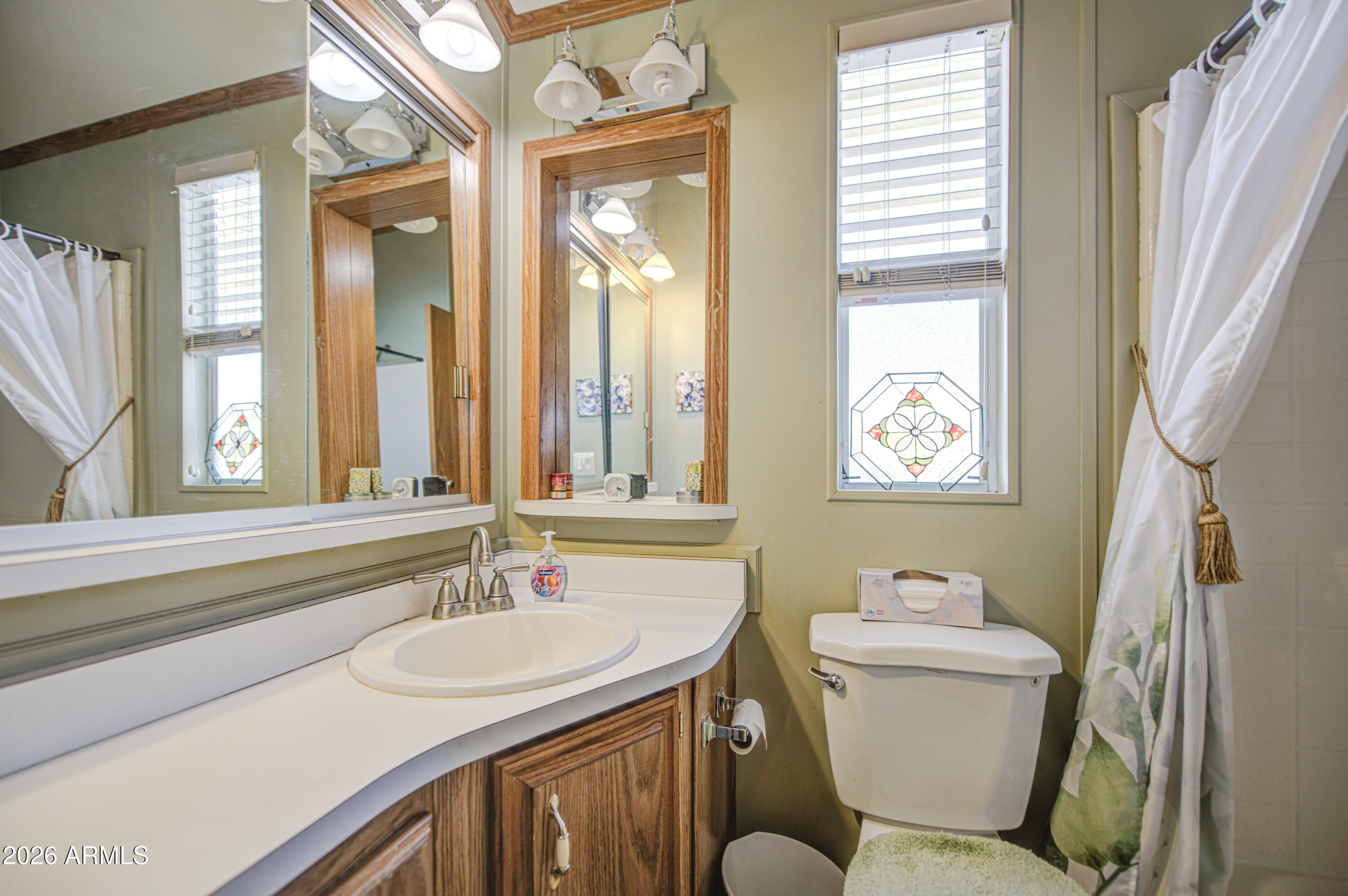 111 South Greenfield Road, Unit 765 Mesa, AZ 85206 - Photo 14 of 31 a bathroom with a granite countertop sink toilet a mirror and a tub