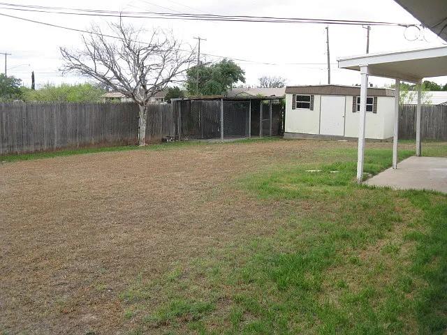 4004 Vicky Street Big Spring, TX 79720 - Photo 13 of 13 Spacious backyard featuring a wood privacy fence, detached storage shed, covered patio, and a chain-link enclosure