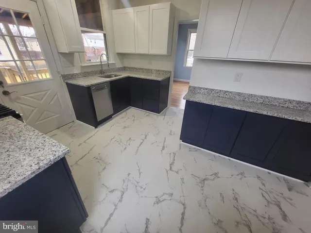 a kitchen with granite countertop sink and cabinets