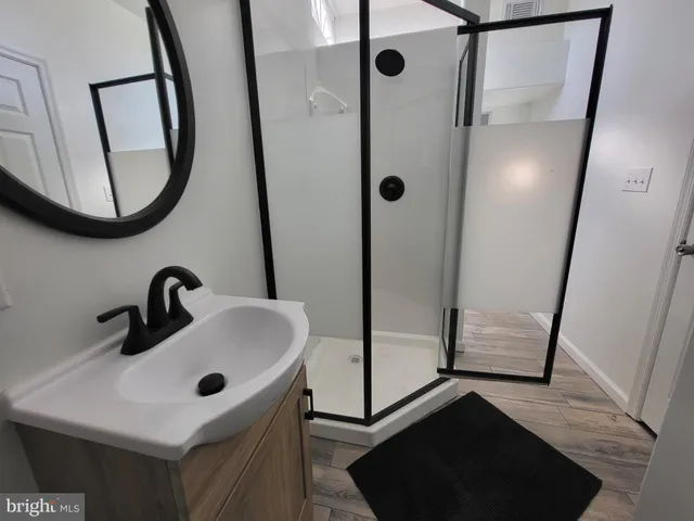 a bathroom with a sink a mirror a vanity and shower