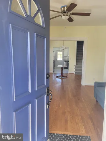 a view of a livingroom with a chair and ceiling fan