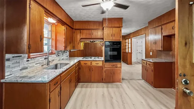 a large kitchen with stainless steel appliances granite countertop a sink refrigerator and cabinets