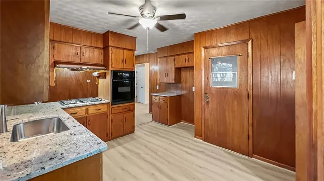 a kitchen with stainless steel appliances granite countertop a sink refrigerator and cabinets