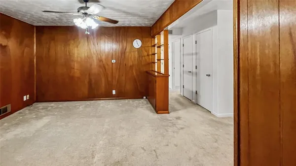 a view of an empty room with a chandelier fan