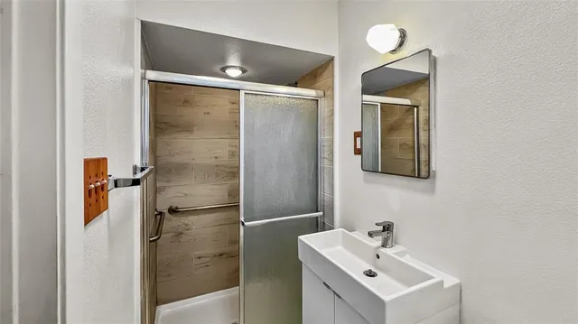 a bathroom with a sink mirror and shower
