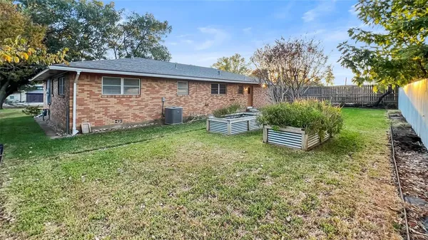 a view of backyard of house with wooden fence
