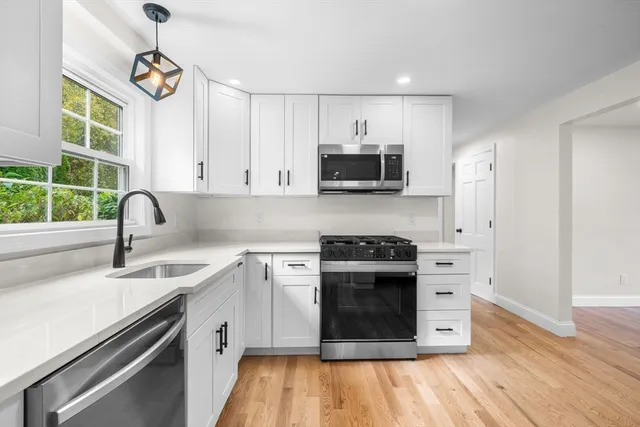 a kitchen with stainless steel appliances granite countertop a sink and a stove top oven
