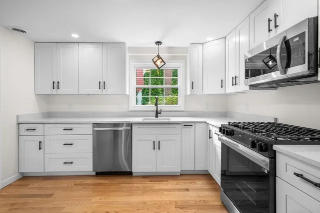 a kitchen with stainless steel appliances granite countertop a stove a sink and a microwave