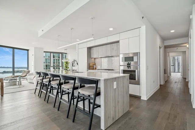 a kitchen with kitchen island granite countertop wooden floors and white stainless steel appliances