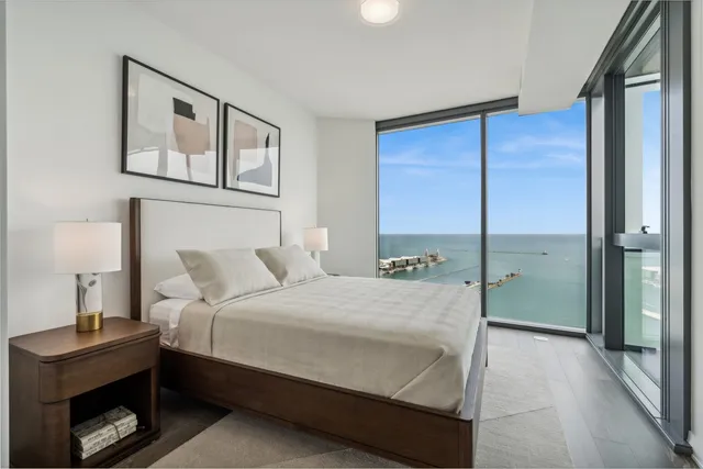 a bedroom with a bed and a lamp on dresser