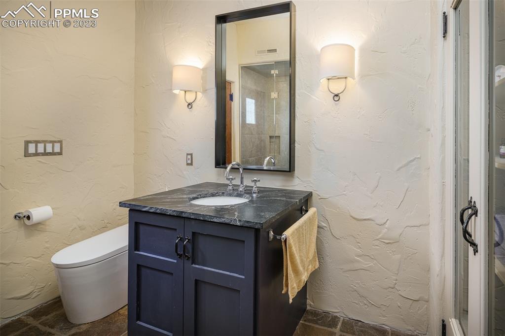 52 Marland Road Colorado Springs, CO 80906 - Photo 20 of 48 a bathroom with a granite countertop sink a toilet and a mirror