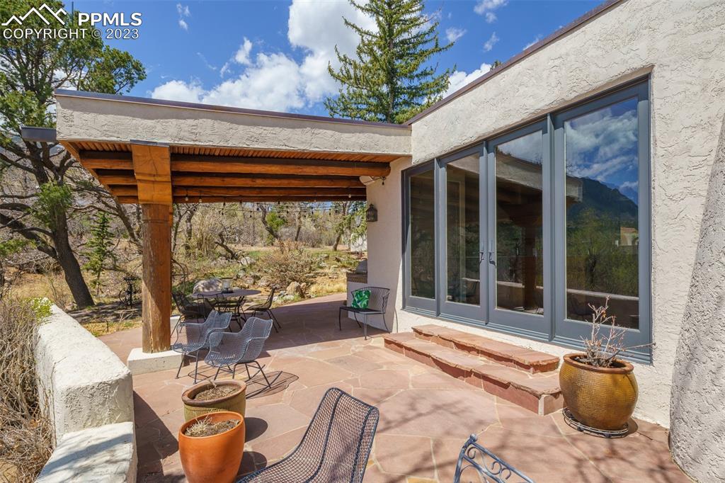 52 Marland Road Colorado Springs, CO 80906 - Photo 38 of 48 a view of a patio with table and chairs potted plants with wooden floor and fence