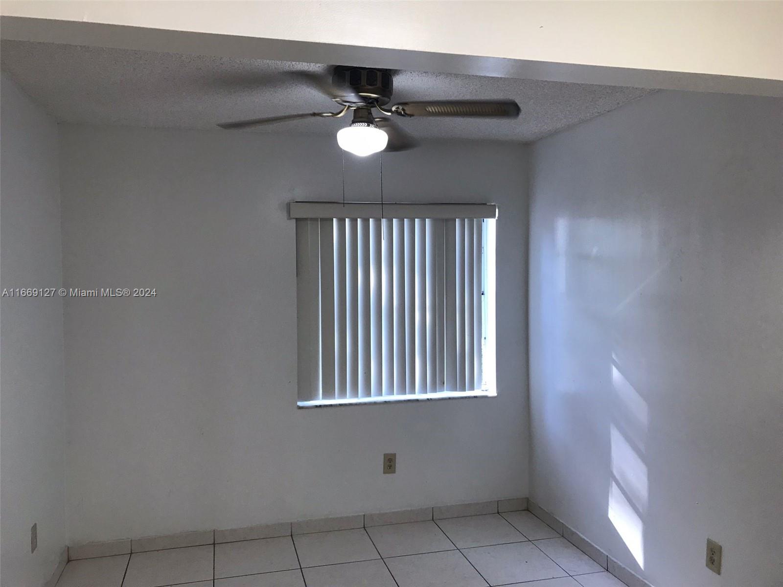 423 Northeast 210th Cir Terrace, Unit 10425 Miami, FL 33179 - Photo 12 of 37 a view of an empty room with a window