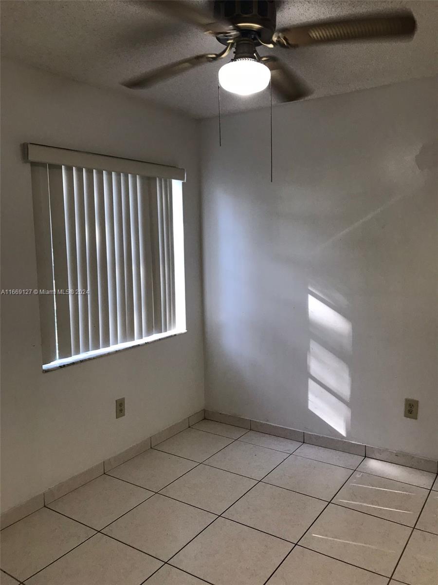 423 Northeast 210th Cir Terrace, Unit 10425 Miami, FL 33179 - Photo 13 of 37 a view of an empty room and window