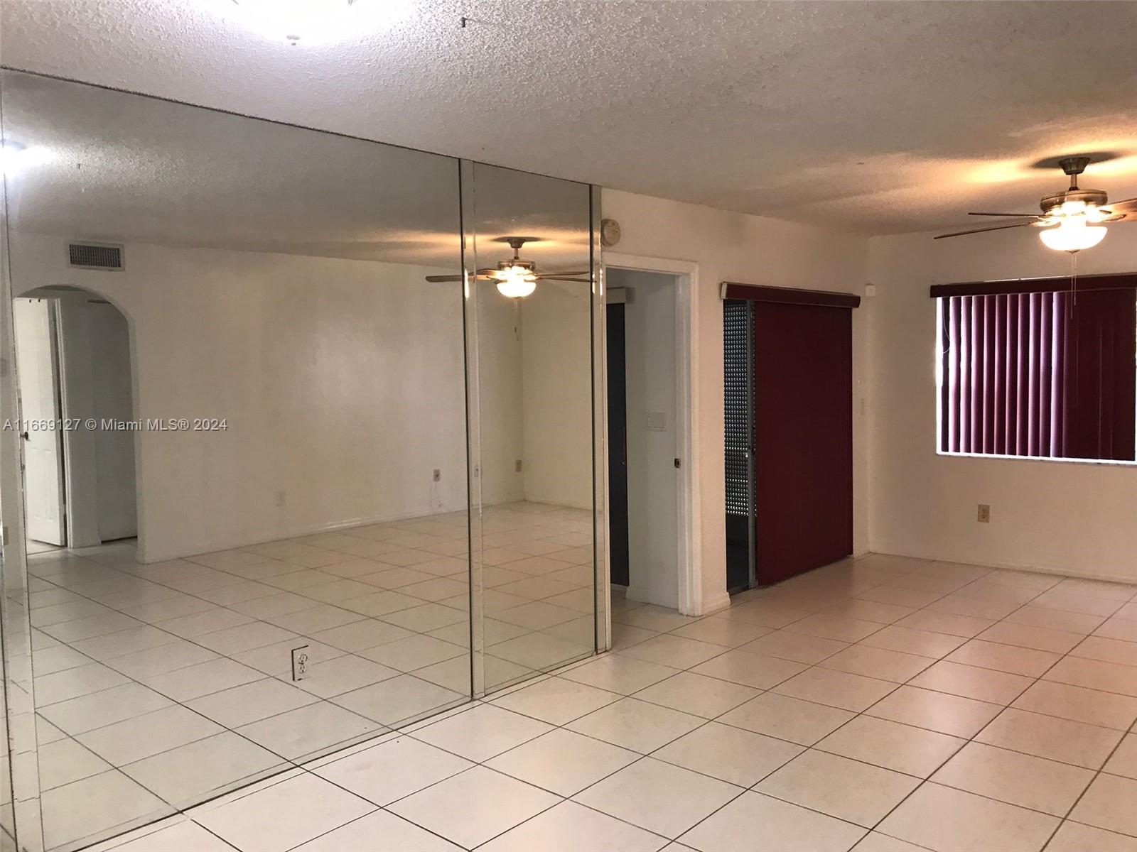 423 Northeast 210th Cir Terrace, Unit 10425 Miami, FL 33179 - Photo 15 of 37 an empty room with staircase and mirror