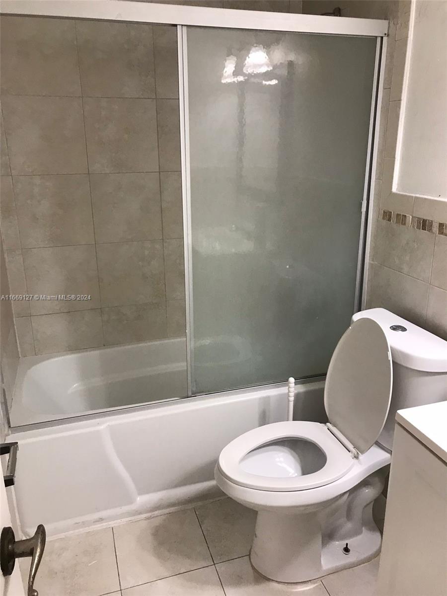 423 Northeast 210th Cir Terrace, Unit 10425 Miami, FL 33179 - Photo 19 of 37 a white toilet sitting next to a bath tub and shower
