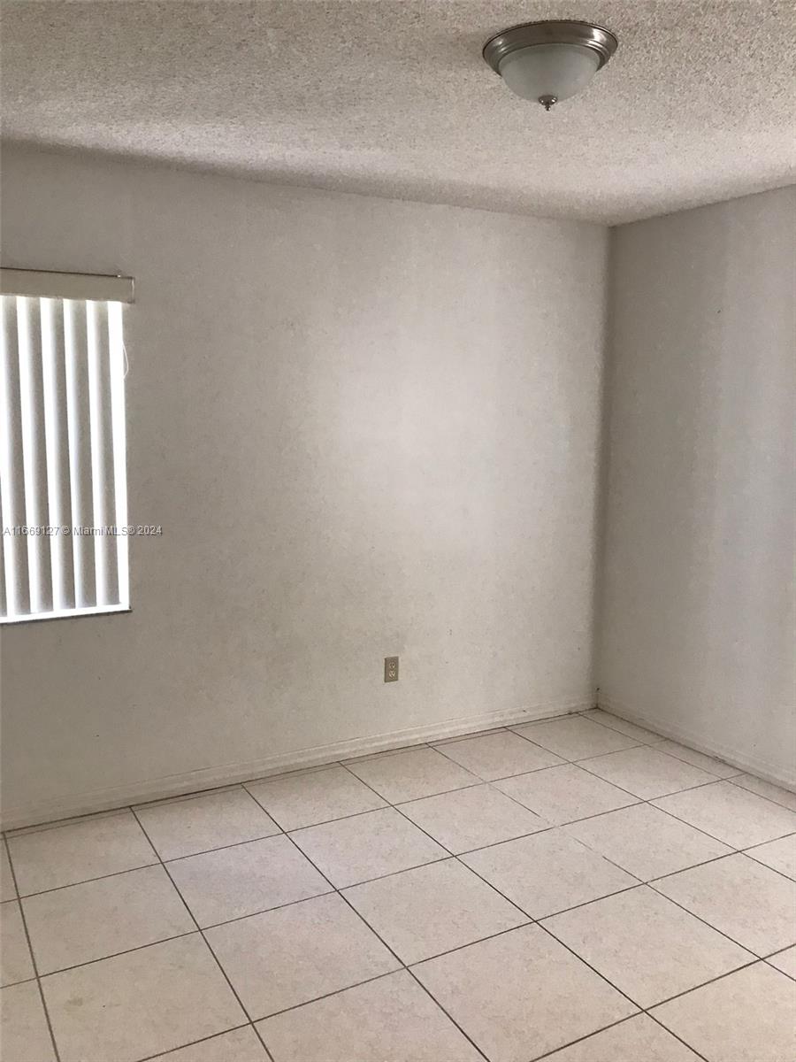 423 Northeast 210th Cir Terrace, Unit 10425 Miami, FL 33179 - Photo 23 of 37 an empty room with windows
